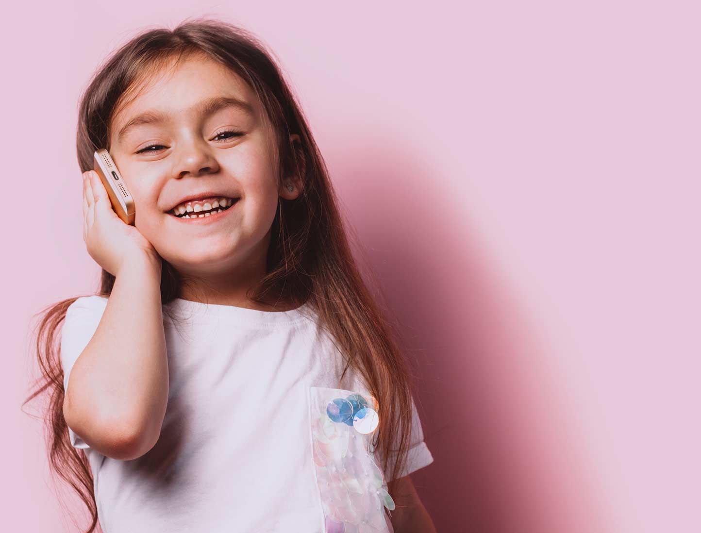 Young girl holding a smartphone, listening to songs on the Bible Stories for the Young app
